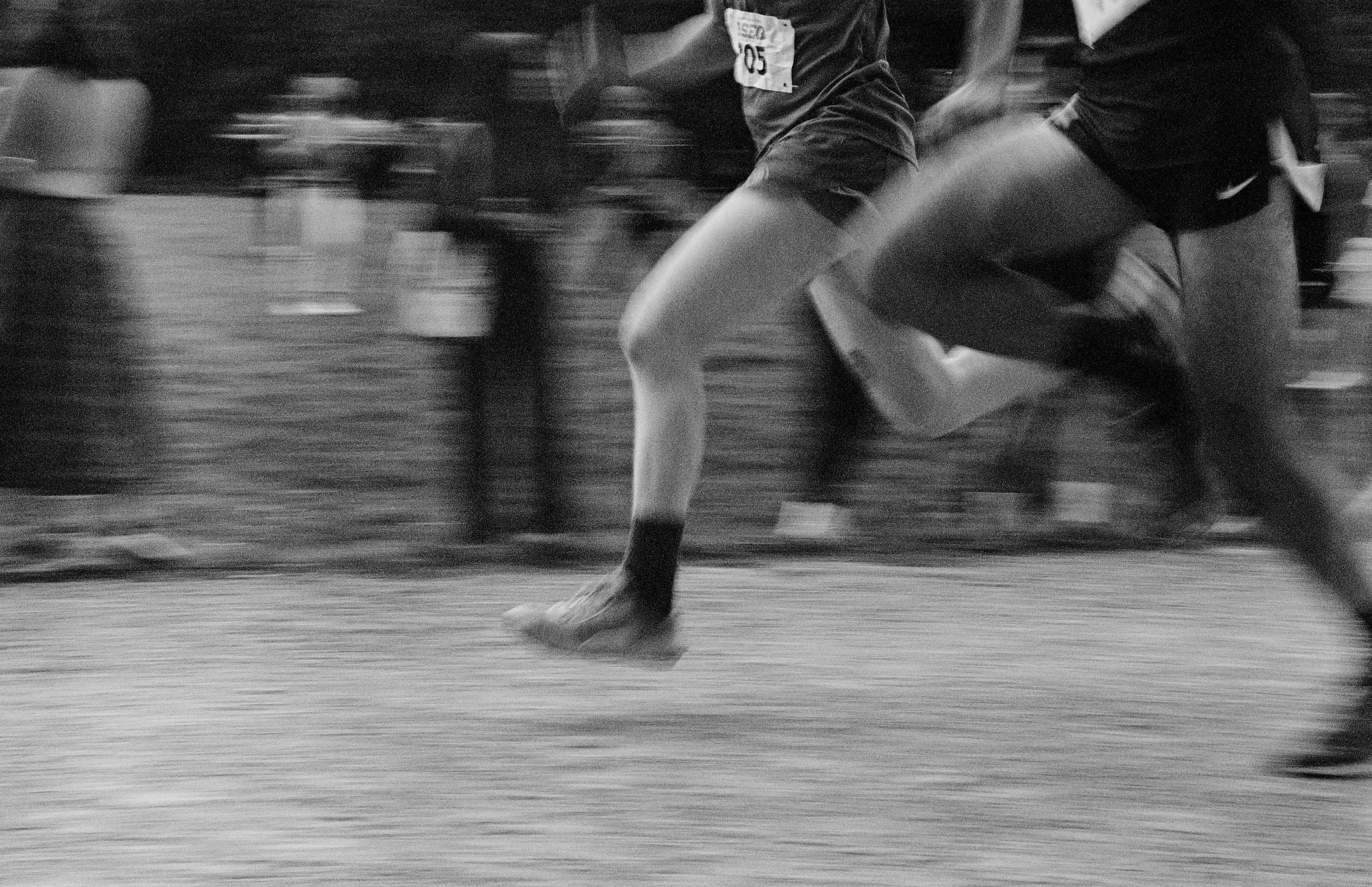 Runners' feet mid-stride, black and white