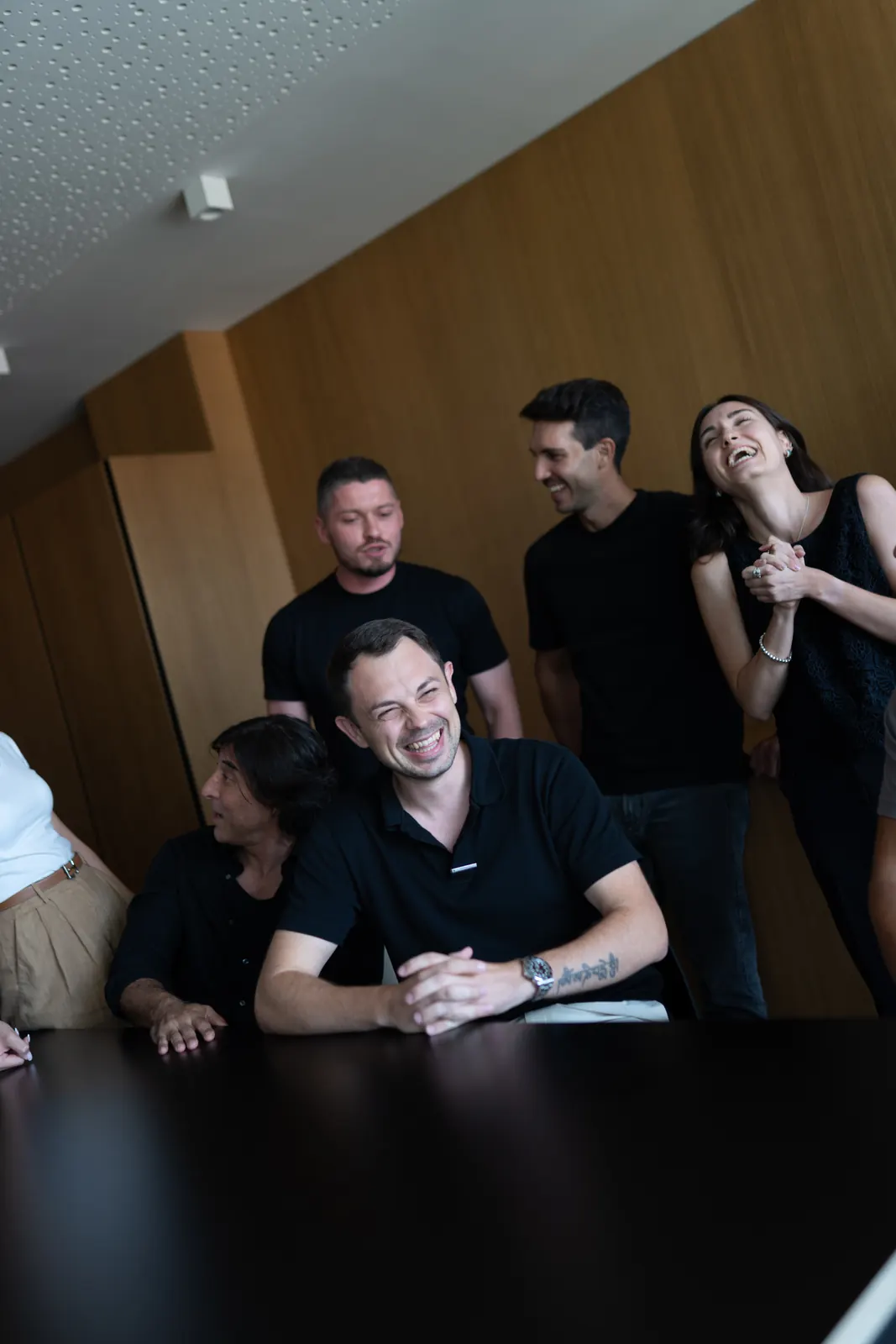 Team members laughing together around a meeting table