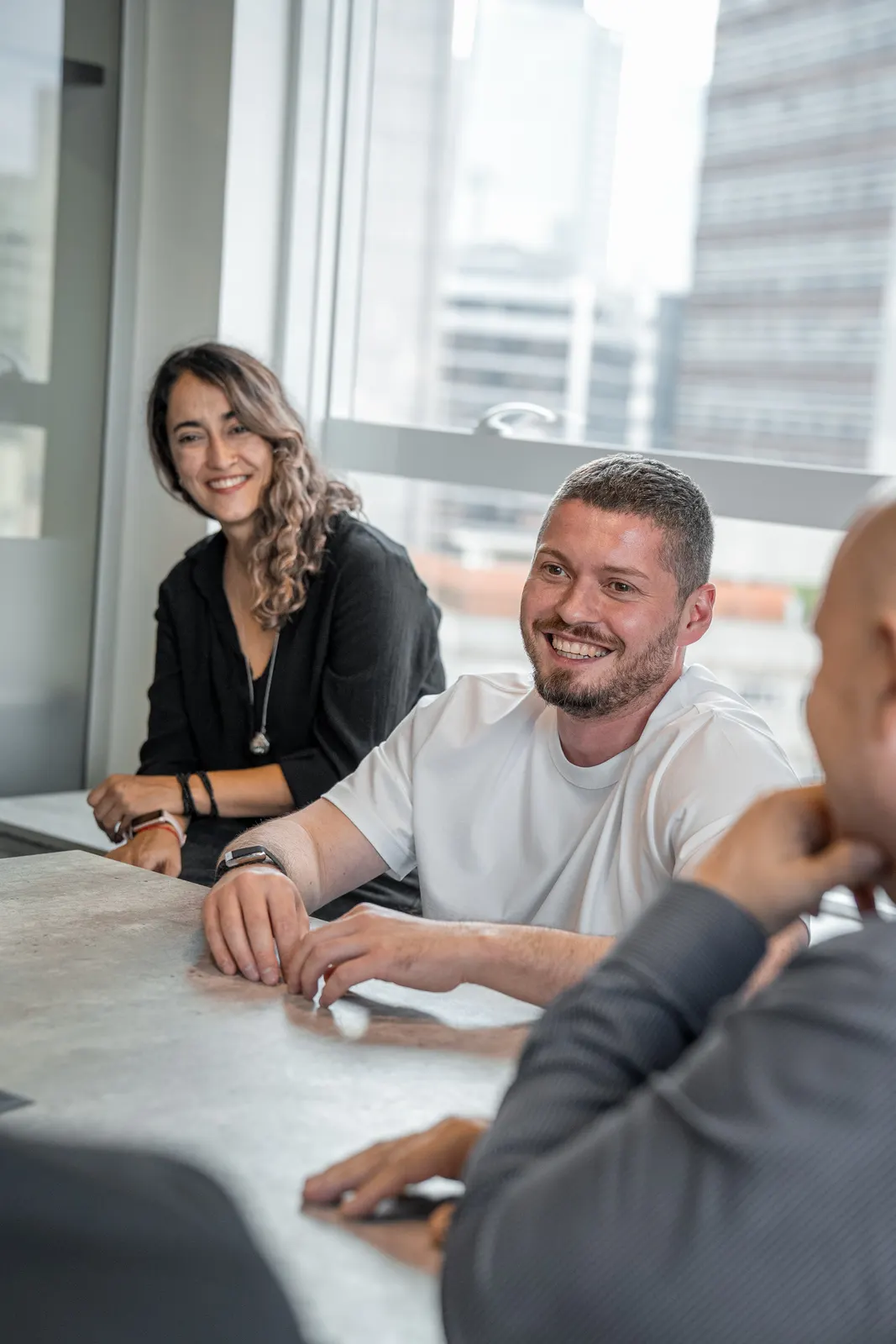 LaFinteca team members smiling during a meeting by the window